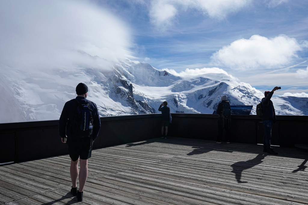Tourists enjoy the view on the Mont-Blanc massif mountains from the Aiguille du Midi, in Chamonix, France, Saturday, Sept. 5, 2026. (AP Photo/Laurent Cipriani)