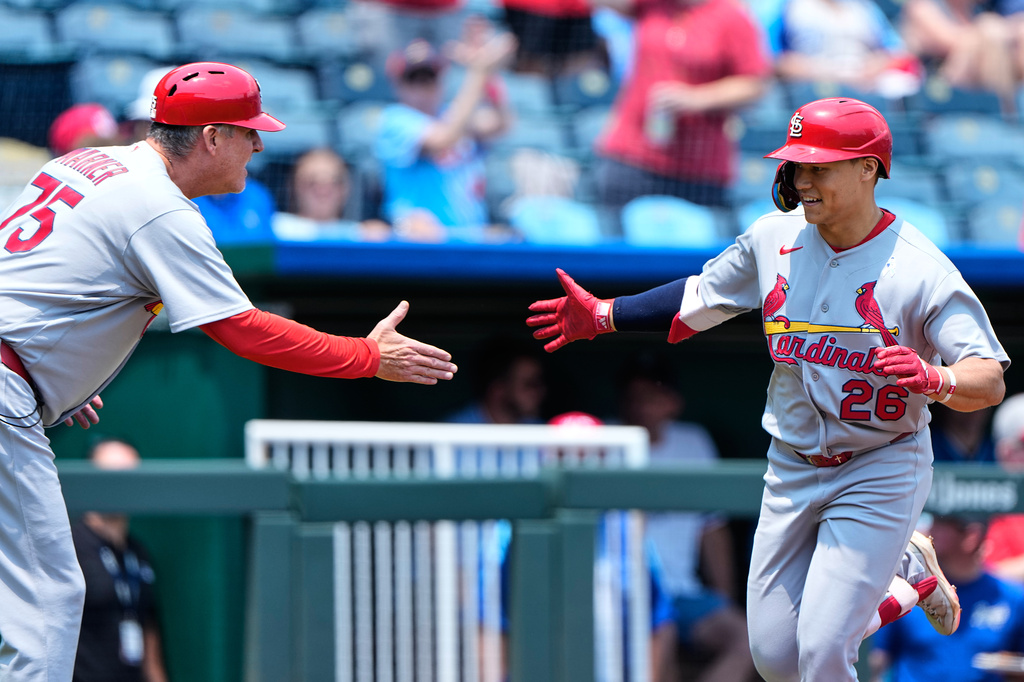 St. Louis Cardinals' JJ Wetherholt (26) celebrates with third base coach Ron 'pop' Warner (75) after hitting a solo home run during the first inning of a baseball game against the Kansas City Royals, Sunday, June 21, 2026, in Kansas City, Mo. (AP Photo/Charlie Riedel)