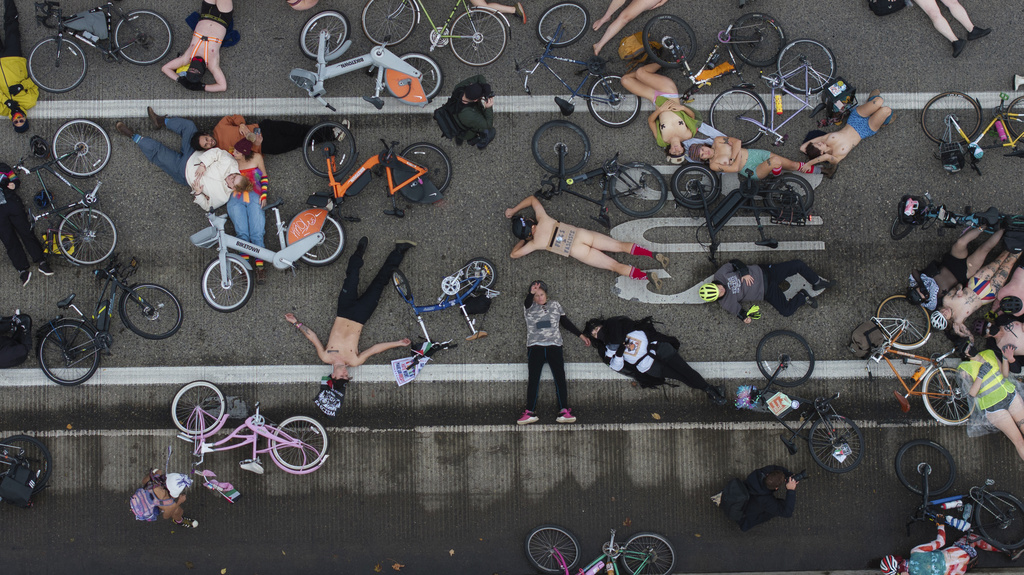 EDS NOTE: NUDITY - Cyclists in the Naked Bike Ride lay down in protest against Donald Trump's attempts to mobilize the National Guard on the Burnside Bridge, Sunday, Oct. 12, 2025, in Portland, Ore. (AP Photo/Jenny Kane)