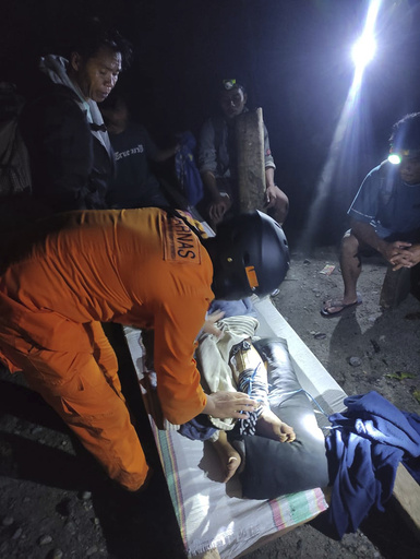 In this photo released by the Indonesian National Search and Rescue Agency (BASARNAS), an injured victim of a landslide is attended to in Suwawa on Sulawesi Island, Indonesia, early Monday, July 8, 2024. The landslide triggered by torrential rains crashed onto an unauthorized gold mining operation on Indonesia's Sulawesi island, killing a number of miners, officials said Monday. (BASARNAS via AP)