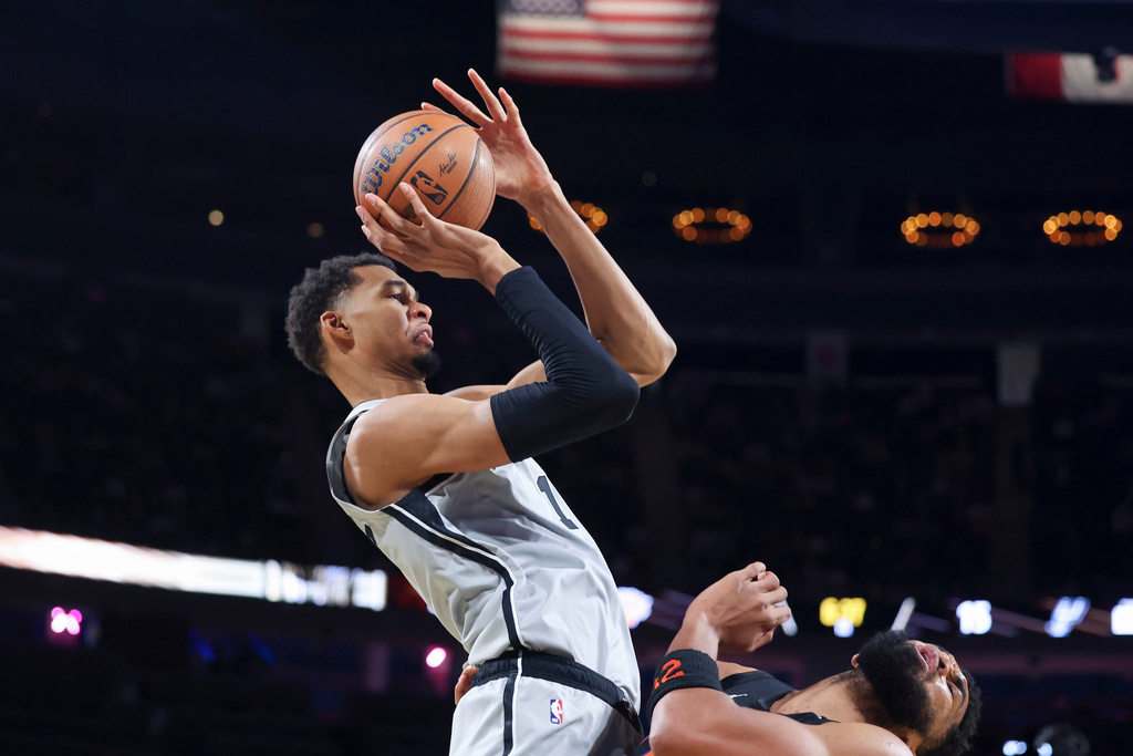 San Antonio Spurs forward Victor Wembanyama (1) shoots against New York Knicks center Karl-Anthony Towns (32) during the first half of the NBA Cup championship basketball game Tuesday, Dec. 16, 2025, in Las Vegas. (AP Photo/Ian Maule)