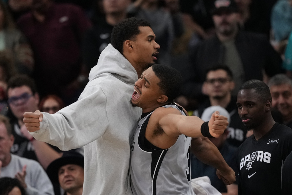 San Antonio Spurs forward Victor Wembanyama, left, and forward Keldon Johnson (3) chest bump during the first half of an NBA basketball game against the Portland Trail Blazers in San Antonio, Saturday, Jan. 3, 2026. (AP Photo/Eric Gay)