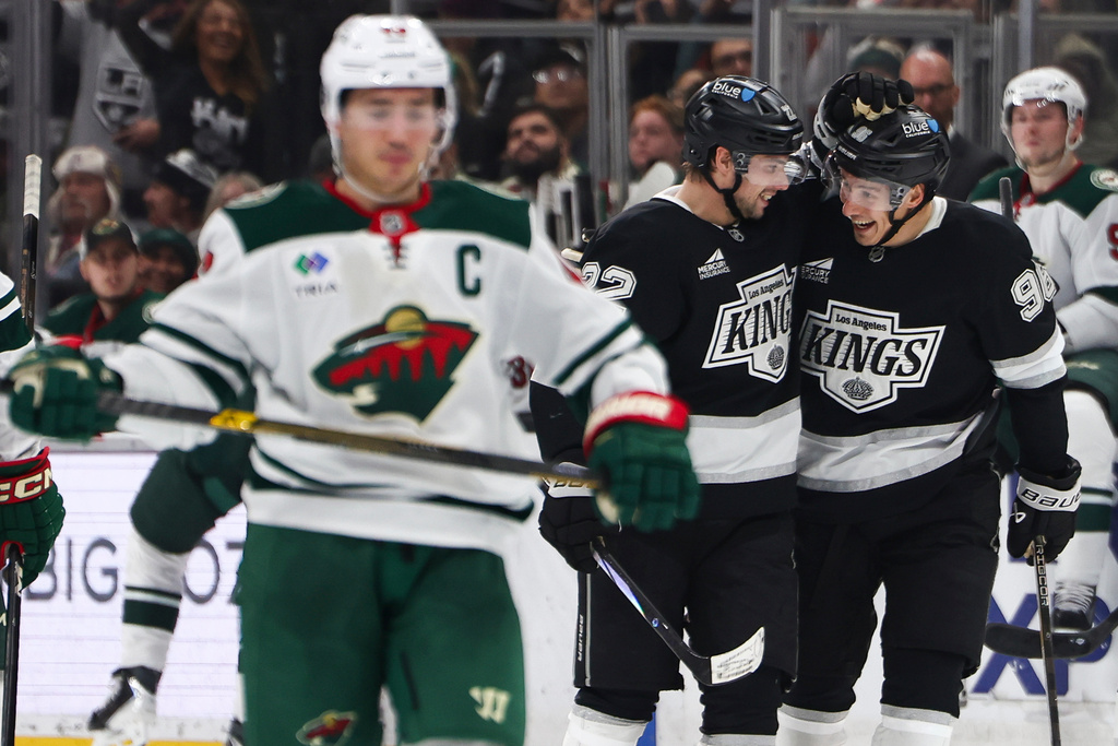 Los Angeles Kings left wing Kevin Fiala, center, and Los Angeles Kings left wing Andrei Kuzmenko (96) celebrate after a goal as Minnesota Wild defenseman Jared Spurgeon, left, skates during the second period of an NHL hockey game, Monday, Jan. 5, 2026, in Los Angeles. (AP Photo/Jessie Alcheh)