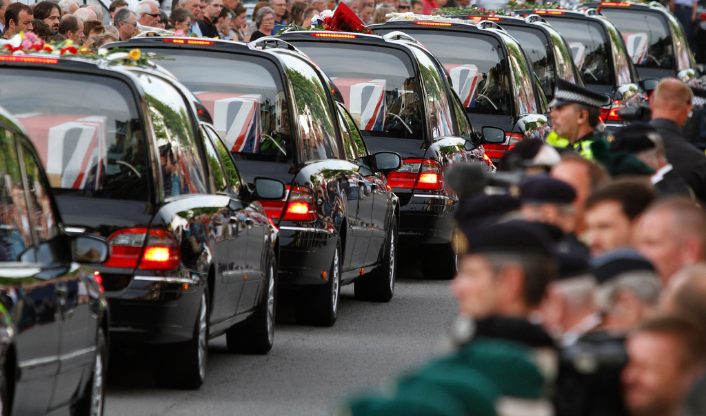FILE - The coffins of seven British soldiers killed in Afghanistan, are driven through the town of Wootton Bassett, England, after repatriation to Britain, Tuesday, June 29, 2010. (AP Photo/Lefteris Pitarakis, file)