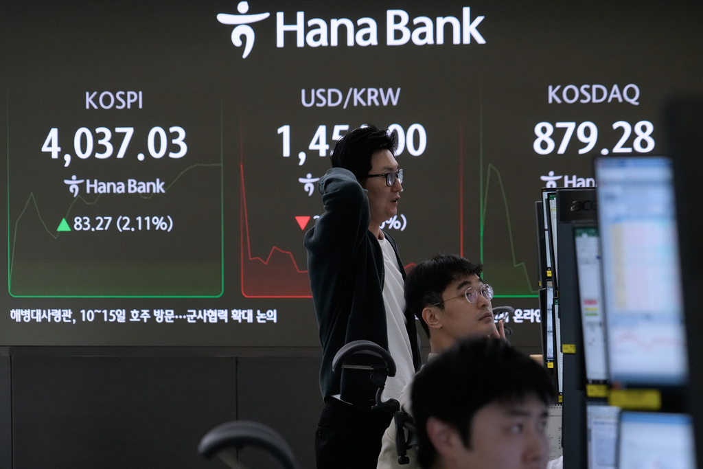 Currency traders watch monitors near a screen showing the Korea Composite Stock Price Index (KOSPI), left, and the foreign exchange rate between U.S. dollar and South Korean won, center, at the foreign exchange dealing room of the Hana Bank headquarters in Seoul, South Korea, Monday, Nov. 10, 2025. (AP Photo/Ahn Young-joon)