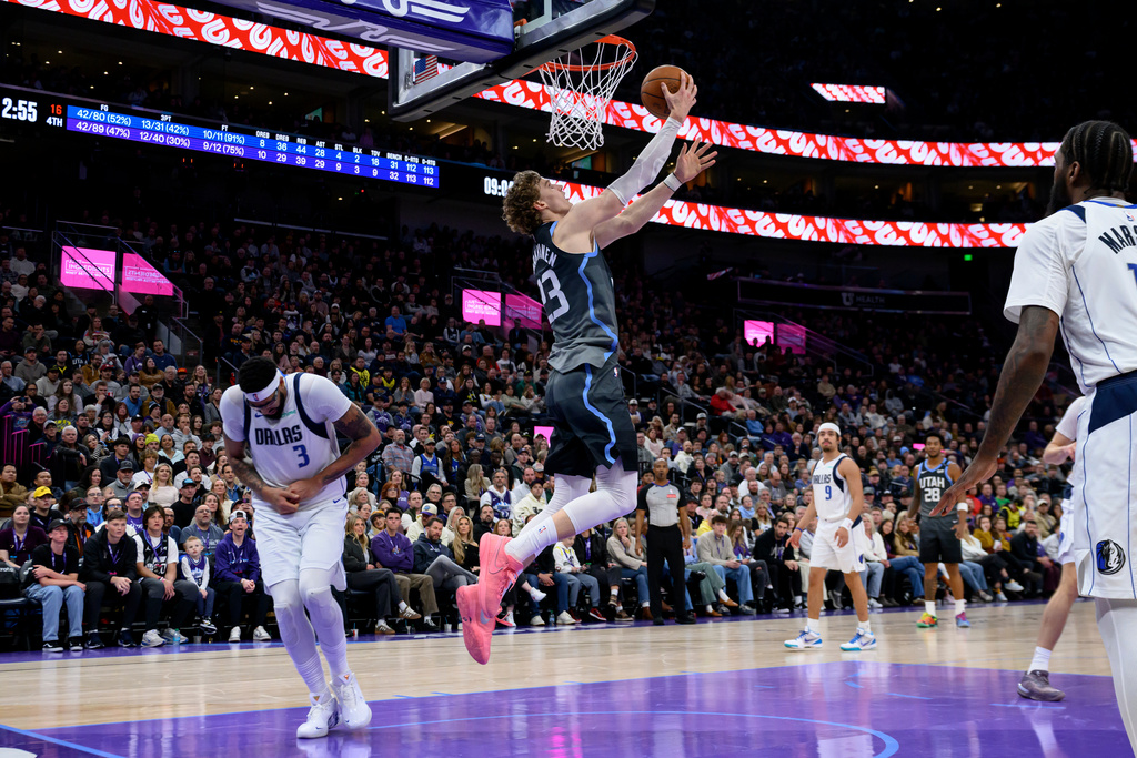Utah Jazz forward Lauri Markkanen, center, lays the ball to the basket as Dallas Mavericks forward Anthony Davis, left, is injured on the play during the second half of an NBA basketball game against the Dallas Mavericks, Thursday, Jan. 8, 2026, in Salt Lake City. (AP Photo/Tyler Tate)