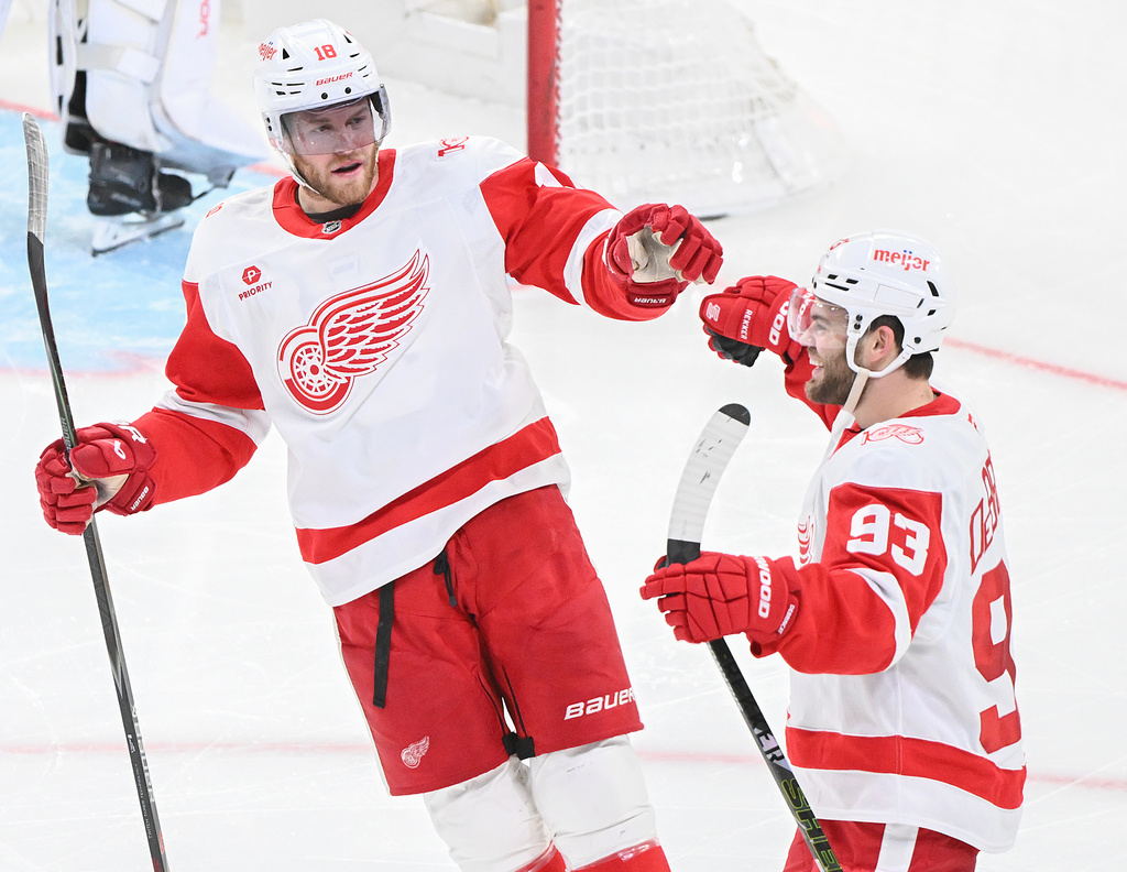 Detroit Red Wings' Alex DeBrincat (93) celebrates with teammate Andrew Copp (18) after scoring against the Montreal Canadiens during the third period of an NHL hockey game in Montreal, Saturday, Jan. 10, 2026. (Graham Hughes/The Canadian Press via AP)