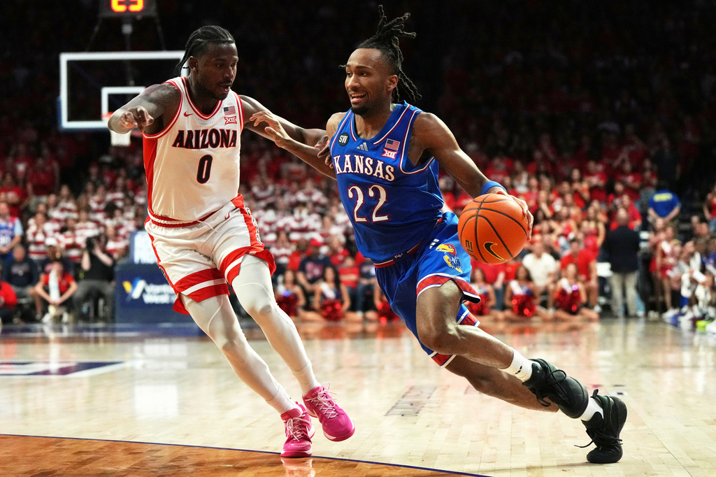 FILE - Kansas guard Darryn Peterson (22) works against Arizona guard Jaden Bradley (0) during the first half of an NCAA college basketball game against Arizona, Feb. 28, 2026, in Tucson, Ariz. (AP Photo/Rick Scuteri, File)