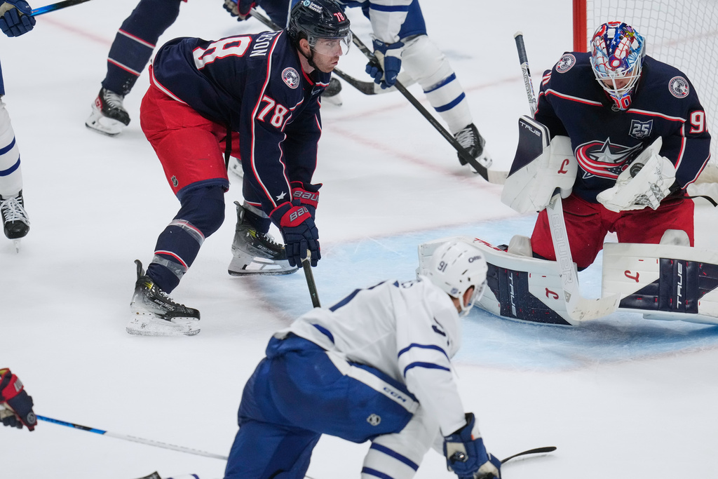 Columbus Blue Jackets goaltender Elvis Merzlikins (90) makes a save on a shot by Toronto Maple Leafs center John Tavares (91) next to defenseman Damon Severson (78) in the second period of an NHL hockey game in Columbus, Wednesday, Oct. 29, 2025. (AP Photo/Sue Ogrocki)