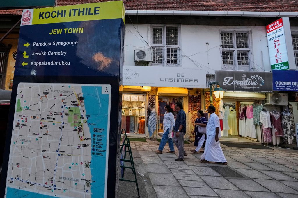 Visitors walk past a sign featuring a map of Kochi and details about the Paradesi Synagogue and the Jewish cemetery in the historic Jew Town neighborhood of Kochi, India, Thursday, May 21, 2026. (AP Photo/Aijaz Rahi)