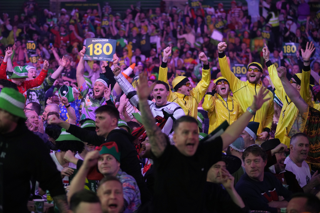 Darts fans reacts as they watch the World Darts Championships, at Alexandra Palace in London, Monday, Dec. 15, 2025. (AP Photo/Kin Cheung)