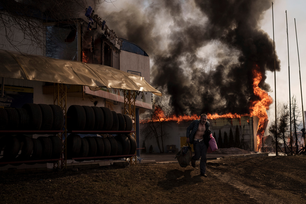 FILE - A man recovers items from a shop that caught fire in a Russian attack in Kharkiv, Ukraine, Friday, March 25, 2022. (AP Photo/Felipe Dana, File)