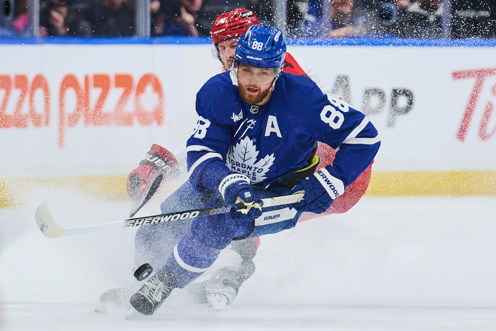 Toronto Maple Leafs' William Nylander (88) battles for the puck with Carolina Hurricanes' Jaccob Slavin (74) during first-period NHL hockey game action in Toronto, Friday, March 20, 2026. (Sammy Kogan/The Canadian Press via AP)