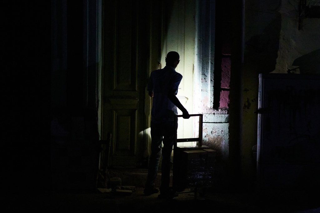 A man enters his building during a blackout in Havana, Monday, March 16, 2026. (AP Photo/Ramon Espinosa)