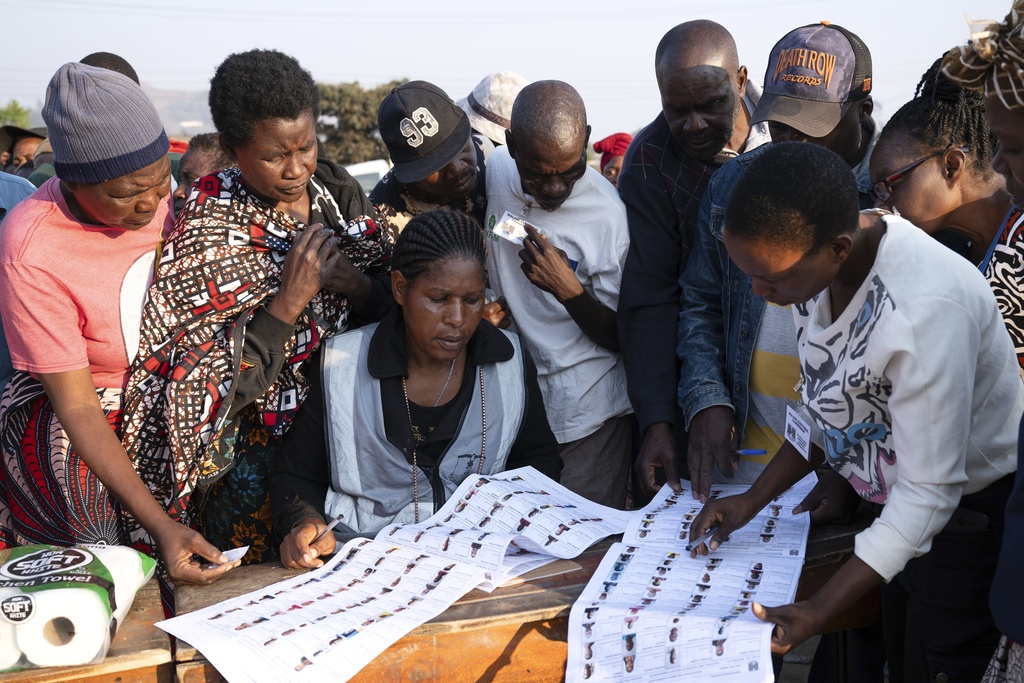 Election worker check names from electoral rolls at a polling station in Blantyre, Malawi, Tuesday, Sept. 16, 2025. (AP Photo/Thoko Chikondi)