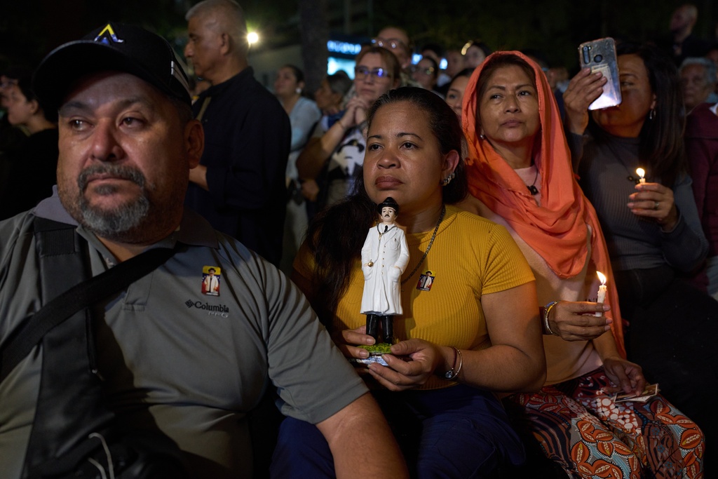 Believers watch the canonization ceremony of Jose Gregorio Hernandez and Mother Carmen Rendiles Martínez by Pope Leo XIV during an event to celebrate Venezuela's first saint at a square in Caracas, Venezuela, Sunday, Oct. 19, 2025. (AP Photo/Ariana Cubillos)