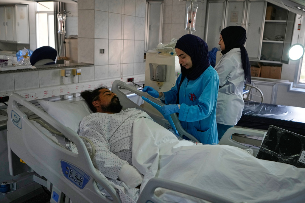 A nurse treats an injured man at the damaged Jabal Amel Hospital, following Monday's Israeli airstrike that was hit a nearby building, in the southern port city of Tyre, Lebanon, Tuesday, June 2, 2026. (AP Photo/Mohammed Zaatari)