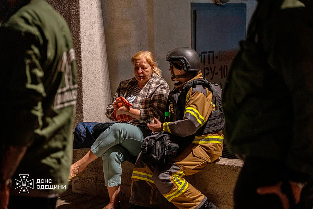 In this photo provided by the Ukrainian Emergency Service, a firefighter, right, comforts a woman after her home was damaged in a Russian air attack in Odesa, Ukraine, Thursday, Sept. 17, 2026. (Ukrainian Emergency Service via AP)