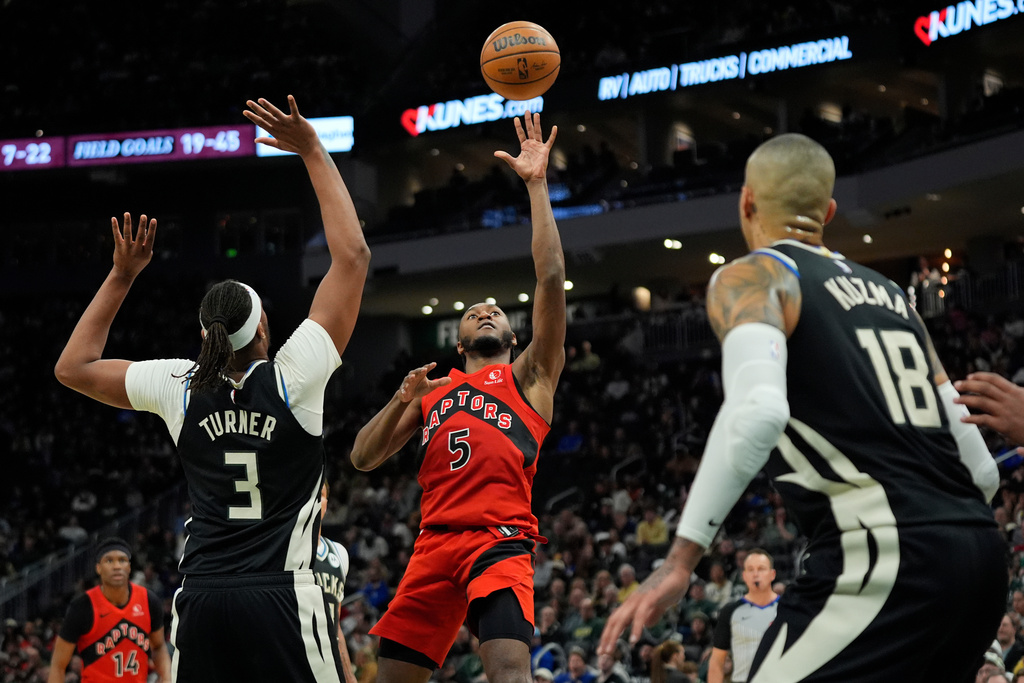 Toronto Raptors' Immanuel Quickley (5) shoots against Milwaukee Bucks' Myles Turner (3) during the first half of an NBA basketball game Sunday, Feb. 22, 2026, in Milwaukee. (AP Photo/Aaron Gash)