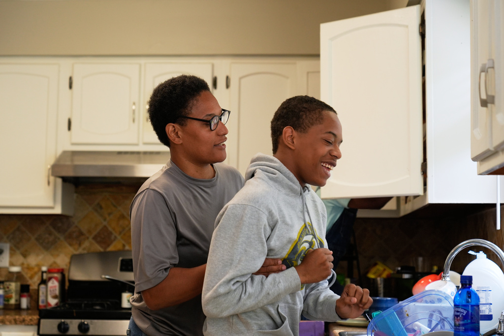 Elias Washington right, laughs with his mother Sechita McNair, left, in the kitchen on June 7, 2025, in Jonesboro, Ga. (AP Photo/Brynn Anderson)
