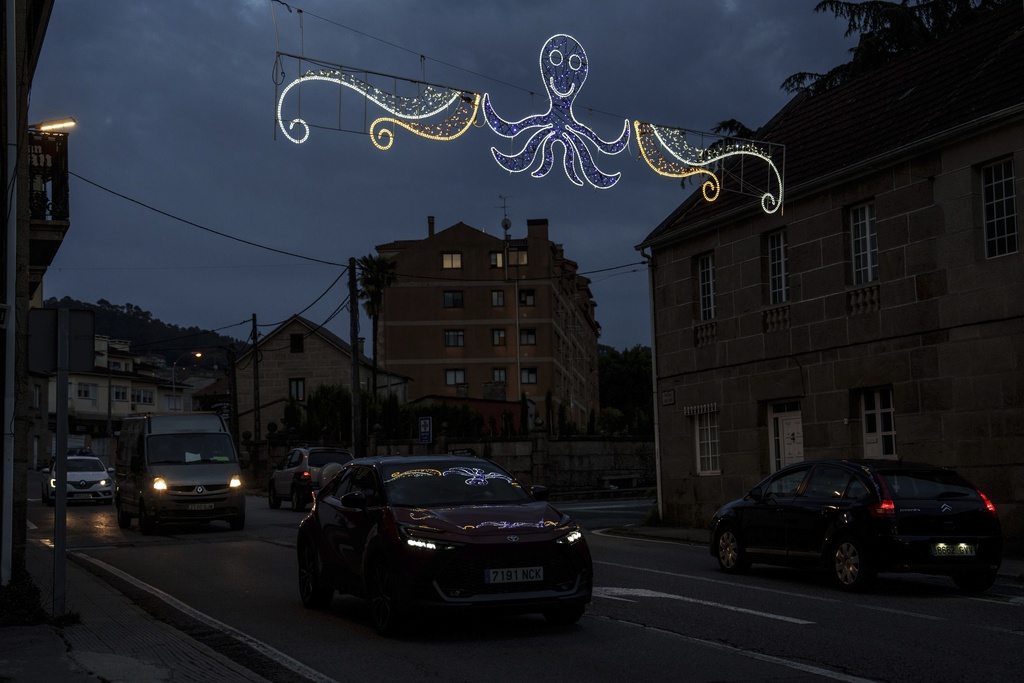 Lights with likeness of an octopus is illuminated over a street Tuesday, June 24, 2025, in Pontevedra, Spain. (AP Photo/Annika Hammerschlag)