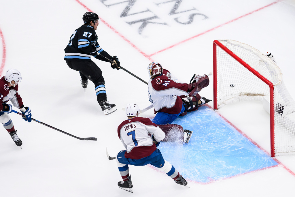 Colorado Avalanche goaltender Scott Wedgewood (41) reaches his glove behind his back to block the shot of Utah Mammoth center Barrett Hayton (27) during the first period of an NHL hockey game, Wednesday, Feb. 25, 2026, in Salt Lake City. (AP Photo/Tyler Tate)