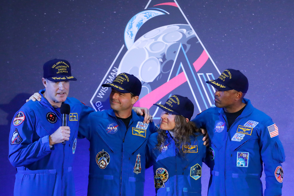 The Artemis II crew, from left, Jeremy Hansen, Reid Wiseman, Christina Koch and Victor Glover gather with Hansen as he speaks during a crew return event Saturday, April 11, 2026, at Ellington Field in Houston. (AP Photo/Michael Wyke)