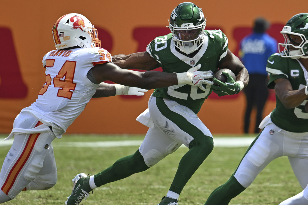 New York Jets running back Breece Hall (20) strong arms Tampa Bay Buccaneers outside linebacker Lavonte David (54) during the first half of an NFL football game Sunday, Sept. 21, 2025, in Tampa, Fla. (AP Photo/Jason Behnken)