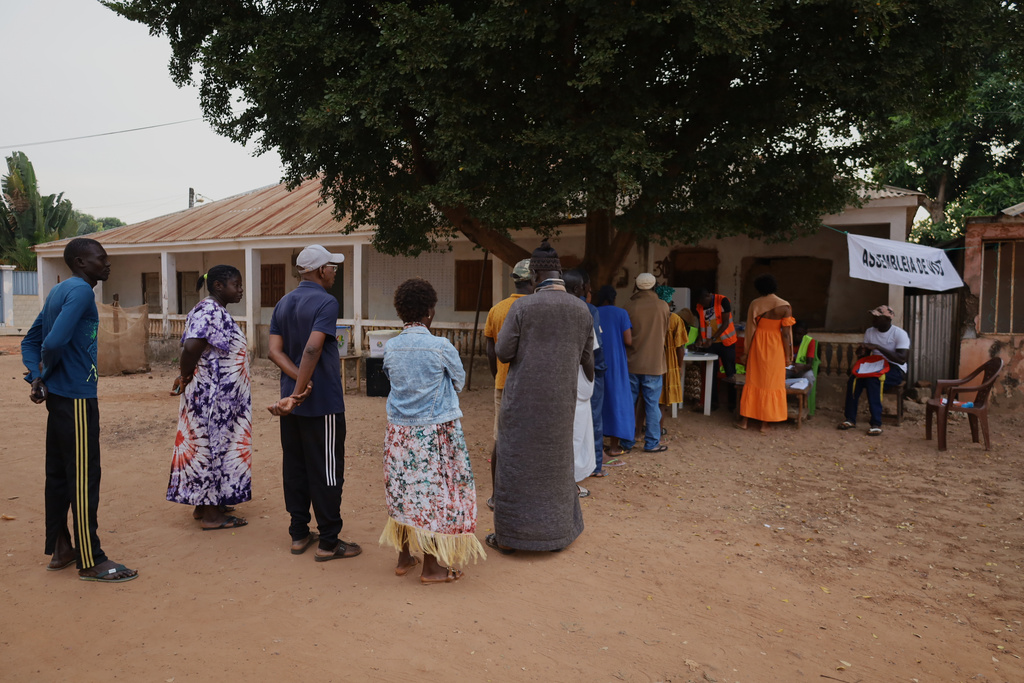 People queue at a polling station to cast their ballots during the presidential and legislative elections, in Bissau, Guinea-Bissau, Sunday, Nov. 23, 2025. (AP Photo/Darcicio Barbosa)