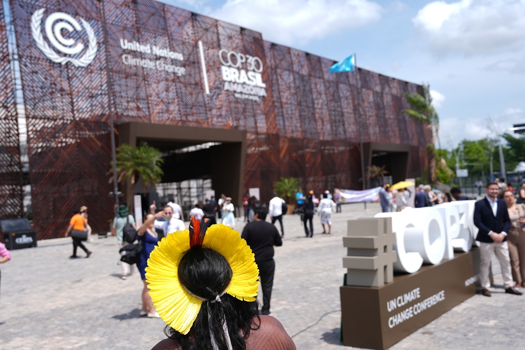 An Indigenous person stands outside the venue for the COP30 U.N. Climate Summit, Tuesday, Nov. 11, 2025, in Belem, Brazil. (AP Photo/Joshua A. Bickel)