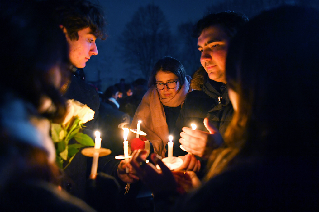 People hold candles during a vigil, Sunday, Dec. 14, 2025, in Providence, R.I., for those injured or killed during the Saturday shooting on Brown University campus. (AP Photo/Steven Senne)