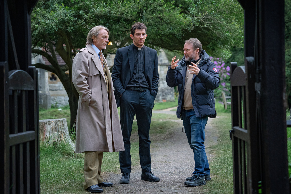 This image released by Netflix shows actors Daniel Craig, left, and Josh O'Connor, center, with writer/director Rian Johnson on the set of "Wake Up Dead Man: A Knives Out Mystery." (John Wilson/Netflix via AP)