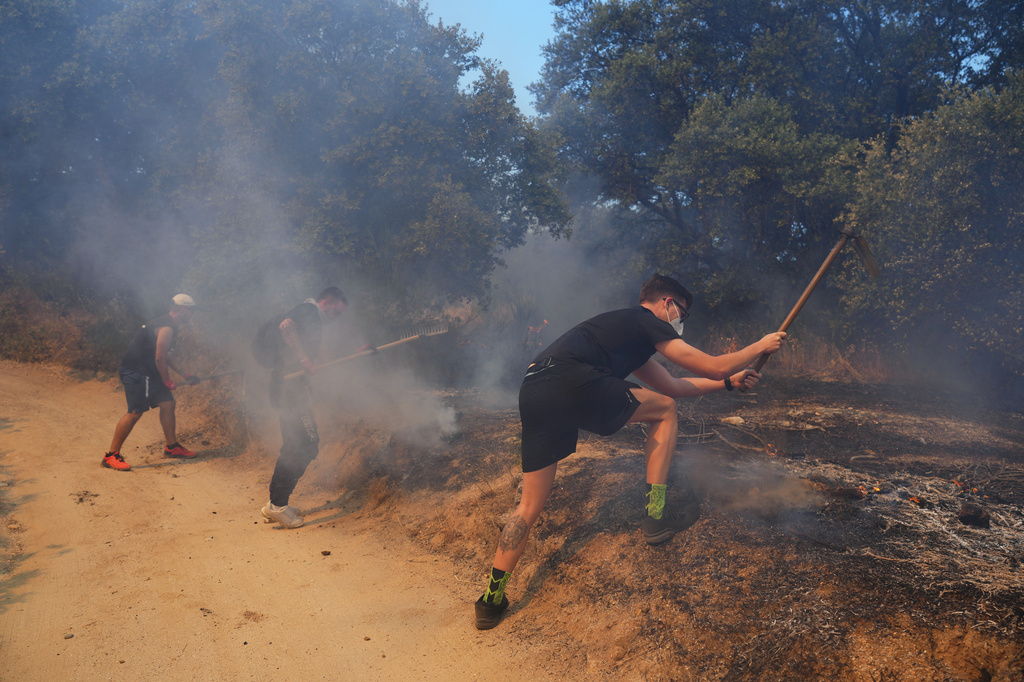 FILE - Volunteers try to help stop a wildfire from advancing in San Martin de Valdeiglesias, west of Madrid, Spain, July 26, 2026. (AP Photo/Manu Fernandez, File)