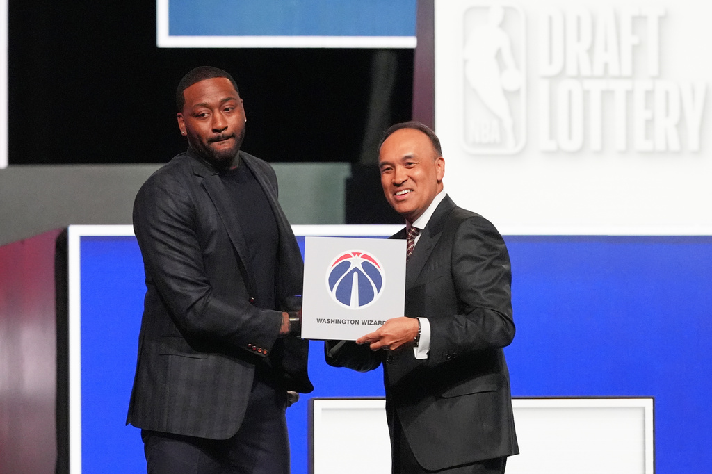 Washington Wizards' John Wall, left, and NBA Deputy Commissioner Mark Tatum, pose for photos after Tatum announced that the Wizards had won the first pick in the NBA basketball draft lottery in Chicago, Sunday, May 10, 2026. (AP Photo/Nam Y. Huh)