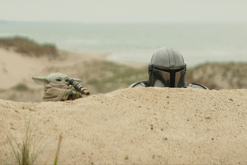 This image released by Disney shows The Mandalorian, portrayed by Pedro Pascal, right, and Grogu in a scene from Lucasfilm's "Star Wars: The Mandalorian and Grogu." (Lucasfilm Ltd. - Disney via AP)