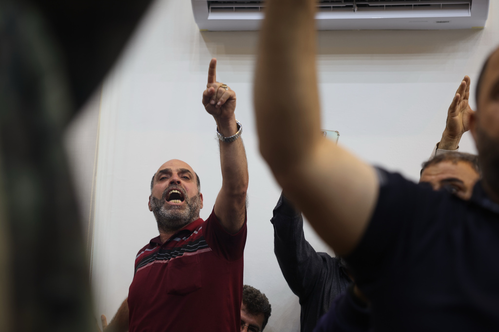 A man shouts as people gather outside the courtroom where the first trial session of Atef Najib, former head of the Political Security Branch in Daraa during Bashar Assad's rule, is taking place, inside the Palace of Justice in Damascus, Syria, Sunday, April 26, 2026. (AP Photo/Ghaith Alsayed)