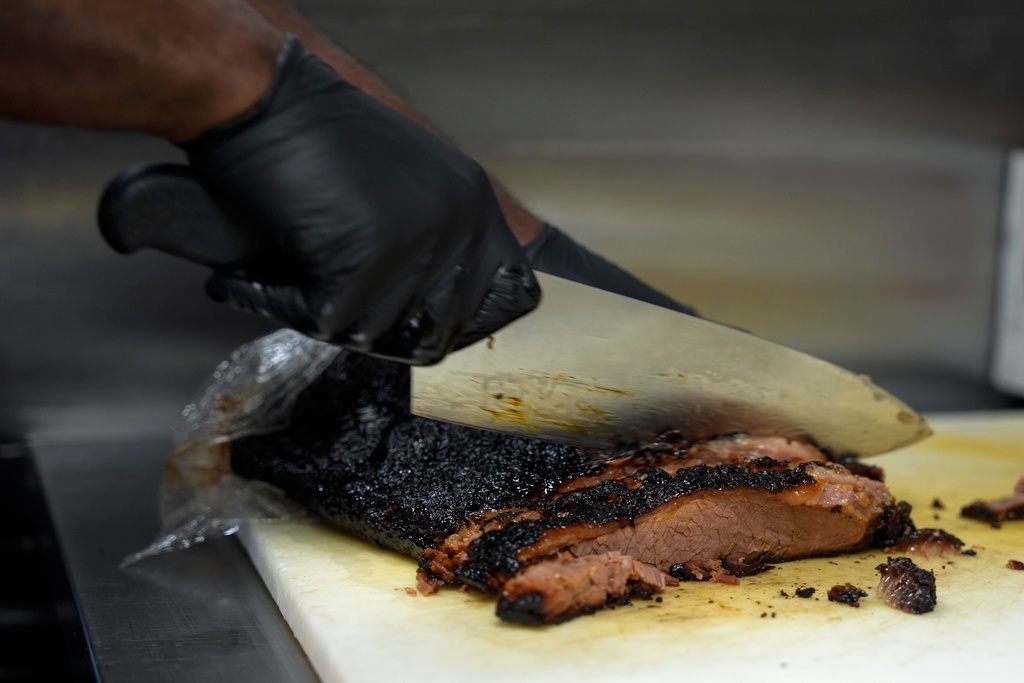 FILE - A line cook slices beef brisket June 12, 2024, at a barbecue restaurant in Cincinnati. (AP Photo/Joshua A. Bickel, File)