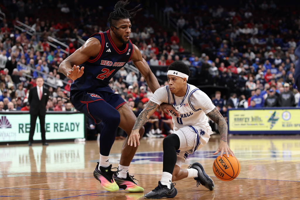 Seton Hall guard Adam Clark (0) drives as he is defended by St. John's forward Zuby Ejiofor (24) during the second half of an NCAA college basketball game Friday, March 6, 2026, in Newark, N.J. (AP Photo/Adam Hunger)
