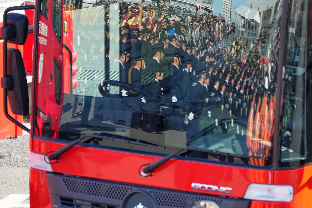 Members of fire brigades are reflected on a front window of the latest fire engine during the annual New Year's Fire Brigade Review Tuesday, Jan. 6, 2026, in Tokyo. (AP Photo/Eugene Hoshiko)