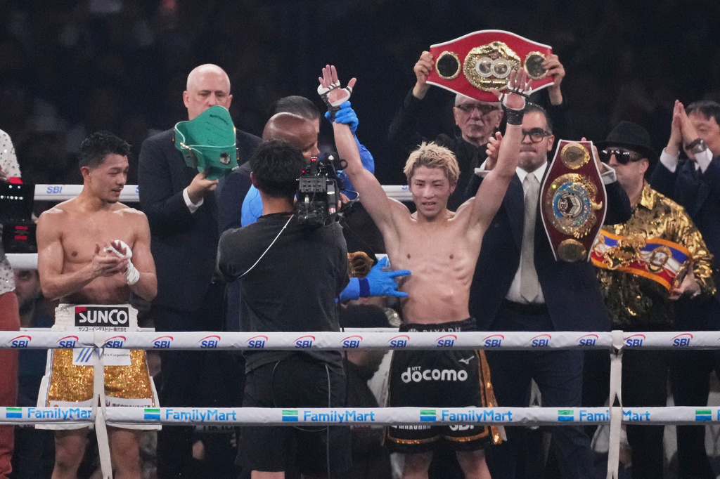 Naoya Inoue of Japan, right, raises his arms as he beat Junto Nakatani of Japan in a boxing match for the WBA, WBC, IBF and WBO super bantamweight world title in Tokyo, Saturday, May 2, 2026. (AP Photo/Hiro Komae)