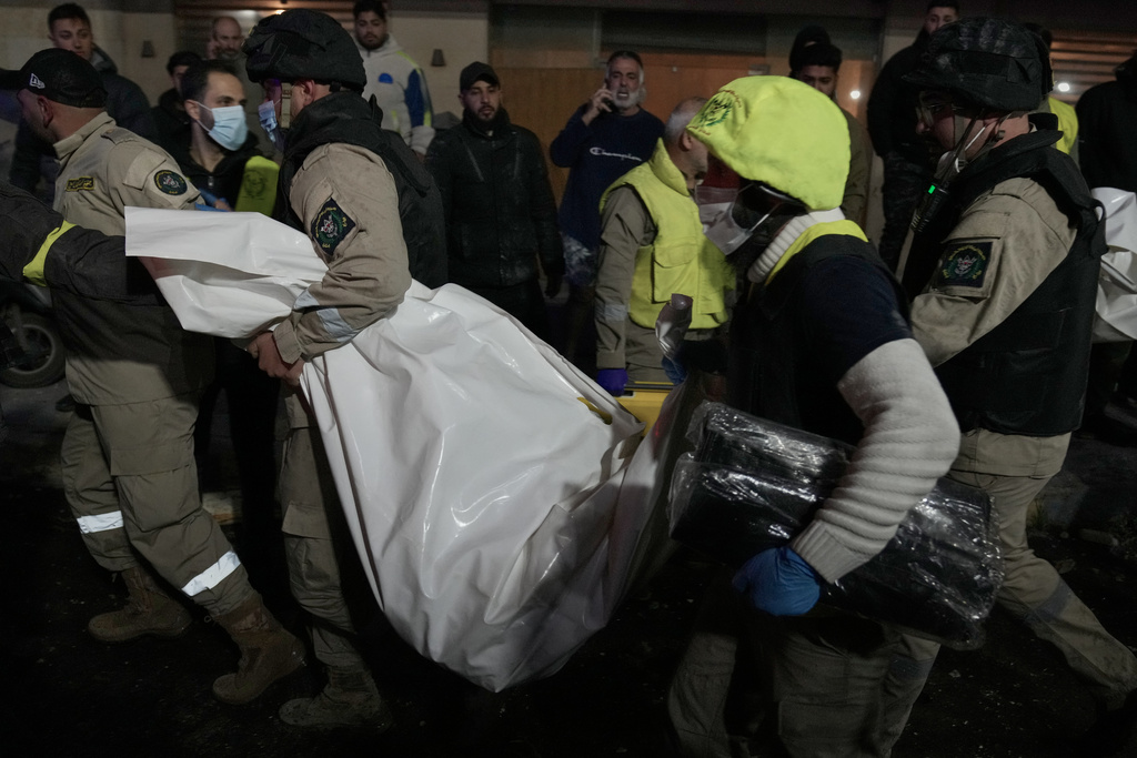 Rescue workers carry a dead body in a plastic bag from a building that was hit by Israeli strike, in Jnah neighborhood, south of Beirut, Lebanon, Monday, March 2, 2026. (AP Photo/Hussein Malla)