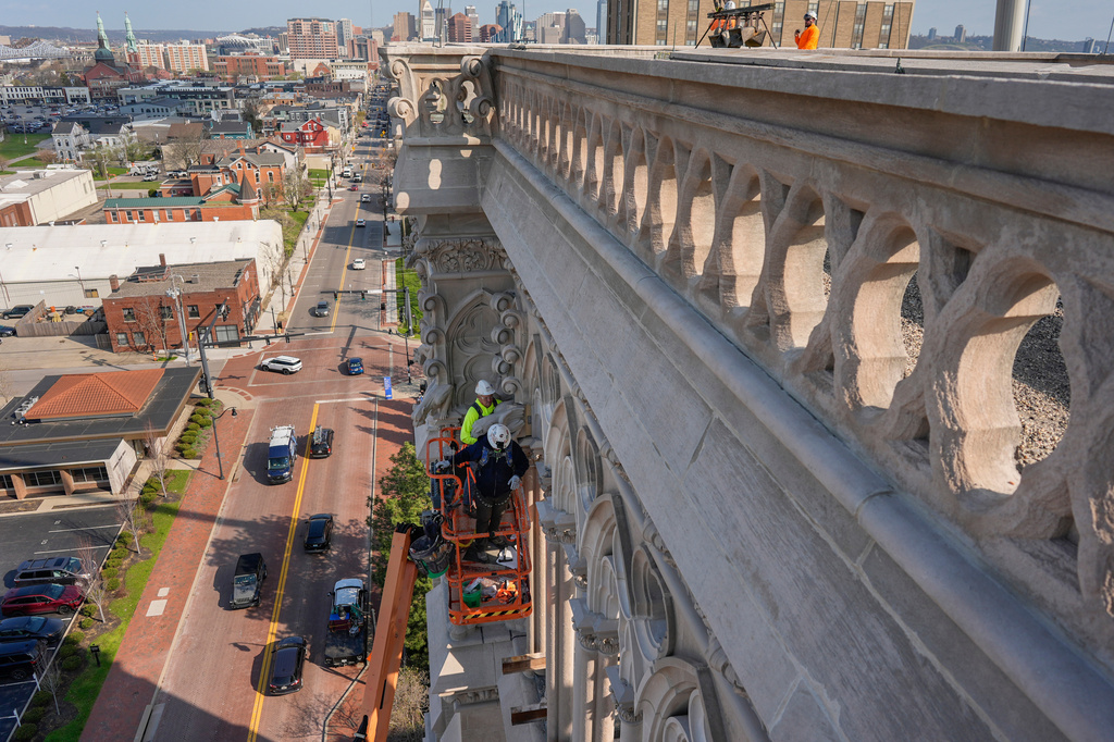 The final new terra cotta gargoyle is installed by Cole Burklund, in the bright yellow, and Blake Priest using a cherry picker high on the Cathedral Basilica of the Assumption, known as "America's Notre Dame," in Covington, Ky., on Monday, March 30, 2026. (AP Photo/Carolyn Kaster)
