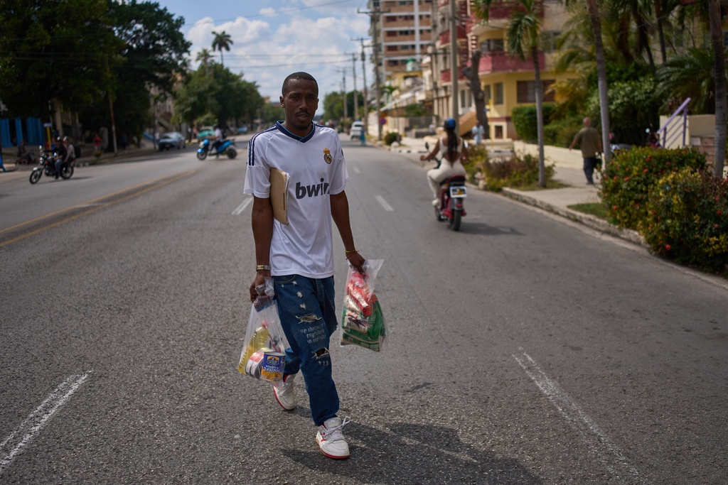 State-run bodega manager Roberto Roman carries bags of donated Mexican humanitarian assistance to be delivered to a family, in Havana, Cuba, Thursday, Feb. 19, 2026. (AP Photo/Ramon Espinosa)