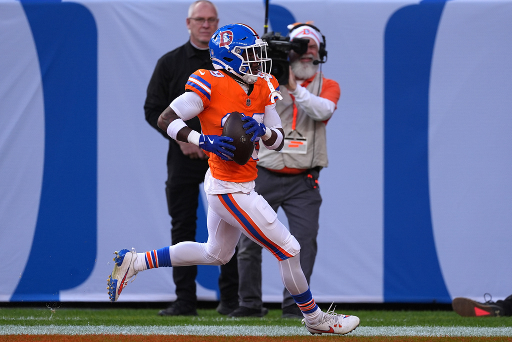 Denver Broncos cornerback Ja'quan McMillian runs for a touchdown after intercepting the ball during the first half of an NFL football game against the Los Angeles Chargers, Sunday, Jan. 4, 2026, in Denver. (AP Photo/David Zalubowski)