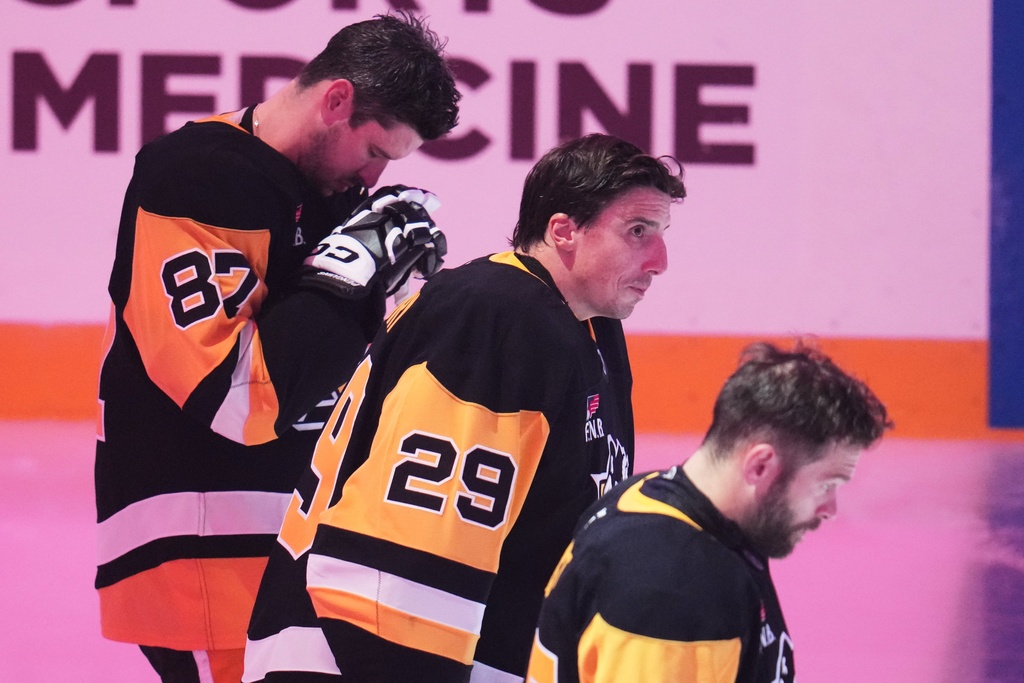 Pittsburgh Penguins' Sidney Crosby (87), Marc-Andre Fleury (29) and Bryan Rust line up for the National Anthem before a pre-season NHL hockey game against the Columbus Blue Jackets in Pittsburgh, Saturday, Sept. 27, 2025. (AP Photo/Gene J. Puskar)