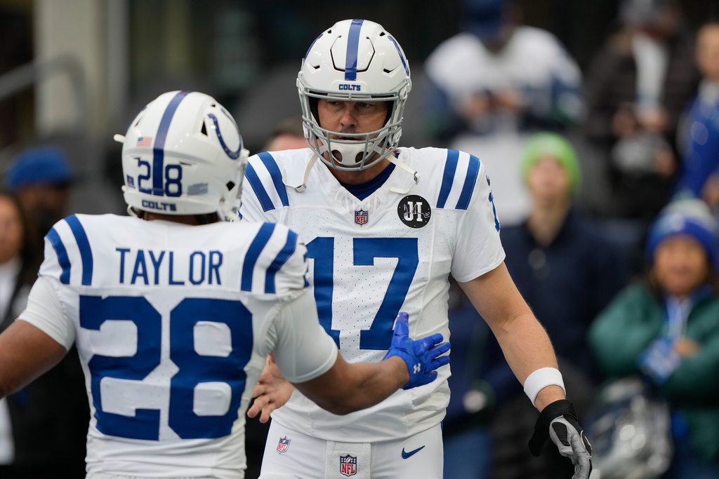 Indianapolis Colts quarterback Philip Rivers (17) greets running back Jonathan Taylor (28) before an NFL football game against the Seattle Seahawks, Sunday, Dec. 14, 2025, in Seattle. (AP Photo/Stephen Brashear)