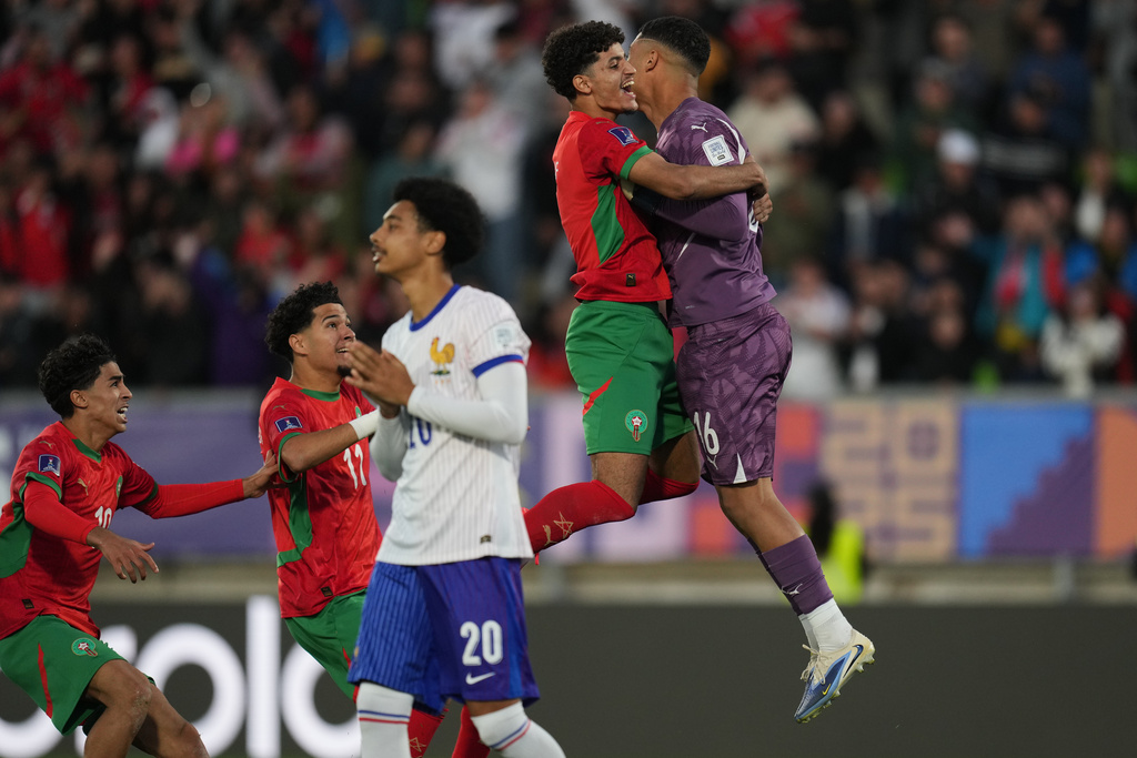 Teammates celebrate with Morocco's goalkeeper Abdelhakim Mesbahi after defeating France in a penalty shootout during a FIFA U-20 World Cup semifinal soccer match at Elias Figueroa Brander Stadium in Valparaiso, Chile, Wednesday, Oct. 15, 2025.(AP Photo/Andre Penner)