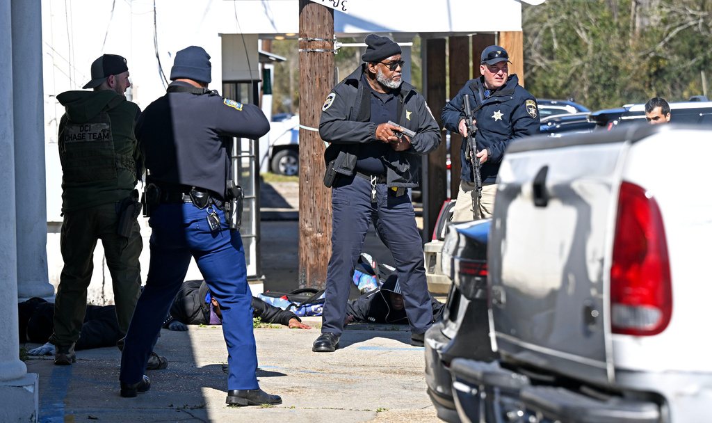 Law enforcement take four people into custody near the scene of a shooting at the Clinton Mardi Gras Parade in Baton Rouge, La., on Saturday, Jan. 31, 2026. (Hilary Scheinuk/The Advocate via AP)