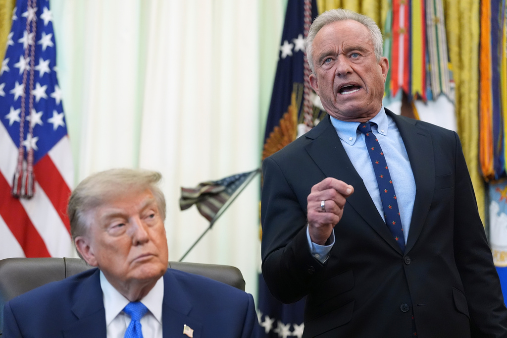 Health and Human Services Secretary Robert F. Kennedy Jr. speaks as President Donald Trump listens during a meeting to sign an executive order about vaccines, Monday, Aug. 10, 2026, in the Oval Office of the White House in Washington. (AP Photo/Jacquelyn Martin)