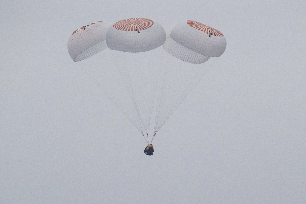 In this image provided by NASA, SpaceX capsule carrying four astronauts, parachutes into the Pacific Ocean off the Southern California coast on Saturday, Aug. 9, 2025. (Keegan Barber/NASA via AP)